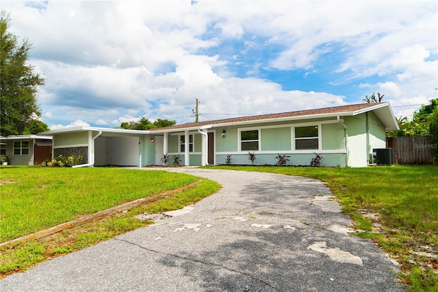 single story home featuring a front lawn and central air condition unit