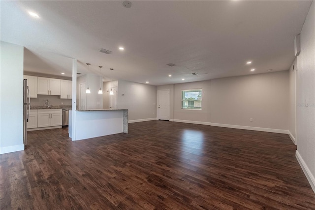 unfurnished living room featuring sink and dark hardwood / wood-style flooring