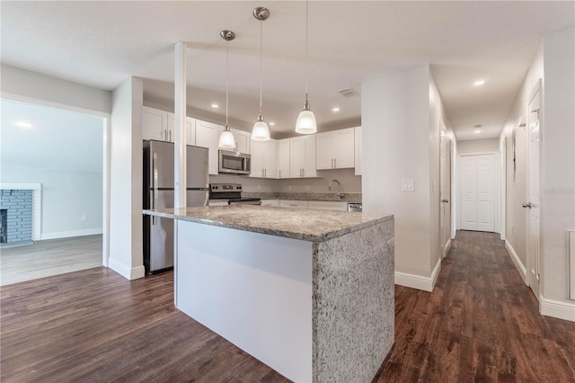 5709 Ridgeway Dr, Orlando, FL 32819 - kitchen featuring stainless steel appliances, a center island, white cabinetry, and dark wood finished floors