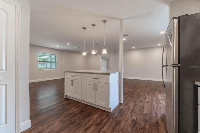 kitchen featuring white cabinets, hanging light fixtures, dark hardwood / wood-style flooring, and stainless steel fridge