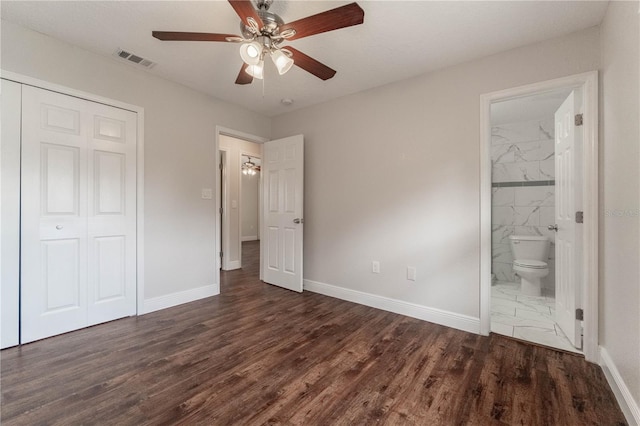 unfurnished bedroom with a closet, ceiling fan, ensuite bathroom, and dark hardwood / wood-style flooring