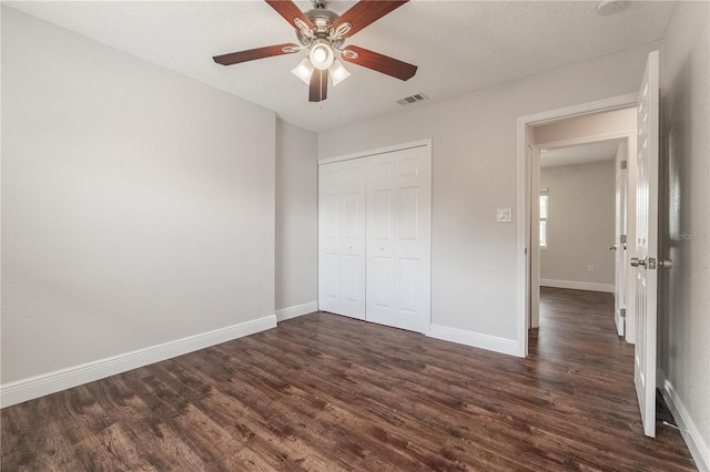 unfurnished bedroom with a textured ceiling, dark hardwood / wood-style floors, a closet, and ceiling fan