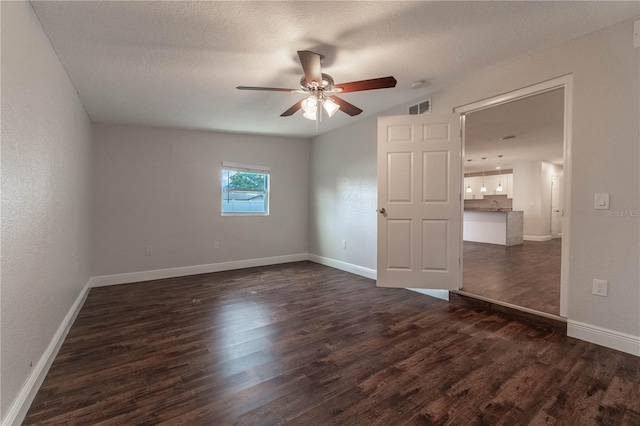 spare room featuring ceiling fan, a textured ceiling, and dark hardwood / wood-style flooring