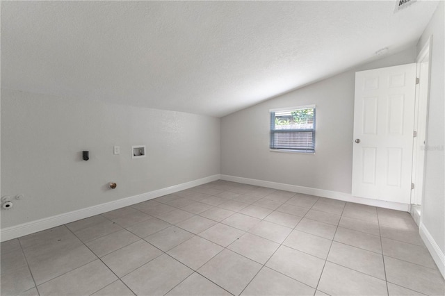 clothes washing area with hookup for a washing machine, a textured ceiling, light tile patterned flooring, and hookup for an electric dryer