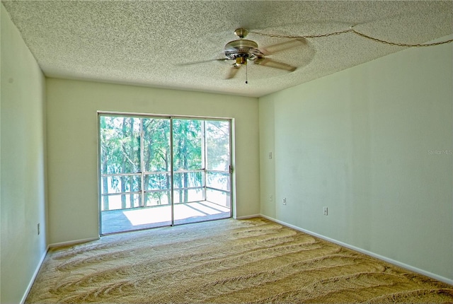 carpeted spare room with ceiling fan and a textured ceiling