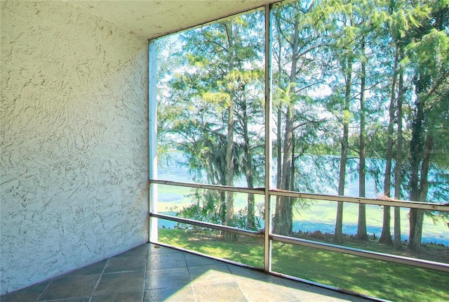 unfurnished sunroom with a water view