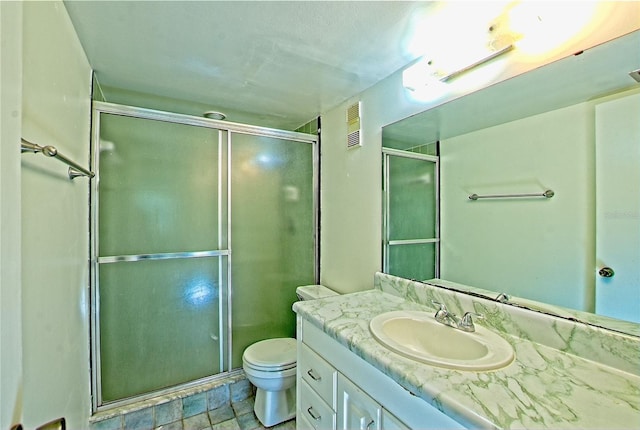 bathroom with vanity, toilet, and a shower with door