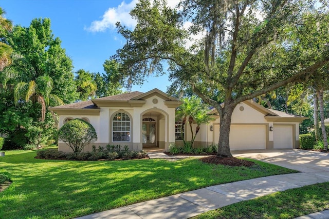 mediterranean / spanish house featuring a front yard and a garage