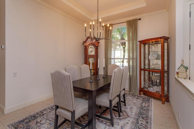 tiled dining room featuring an inviting chandelier, a tray ceiling, and ornamental molding