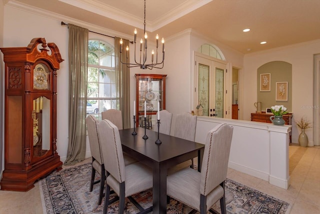 dining space with french doors, a notable chandelier, ornamental molding, and light tile patterned flooring