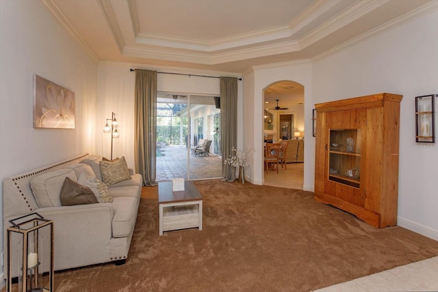 living room with carpet, a tray ceiling, crown molding, and ceiling fan