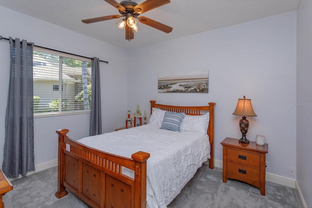 carpeted bedroom featuring a textured ceiling and ceiling fan