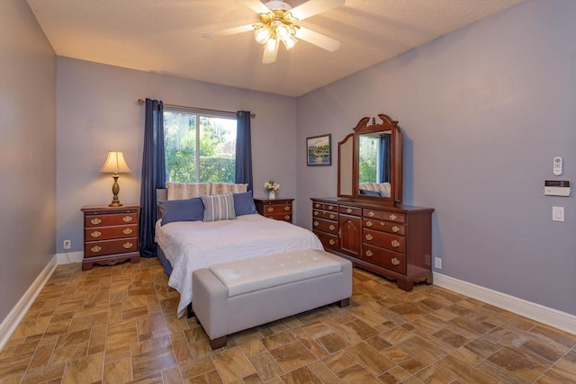 bedroom with ceiling fan and a textured ceiling