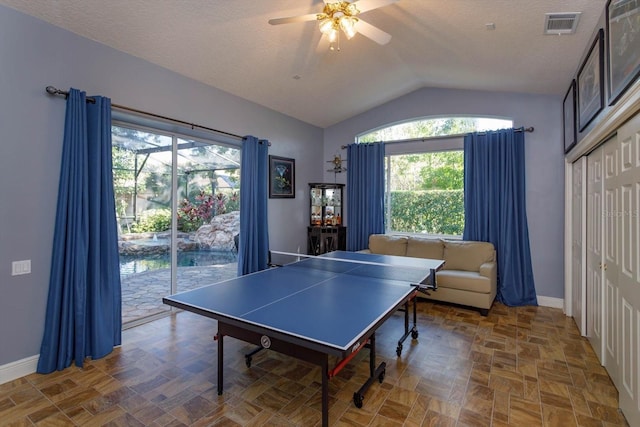 recreation room featuring a textured ceiling, vaulted ceiling, and ceiling fan