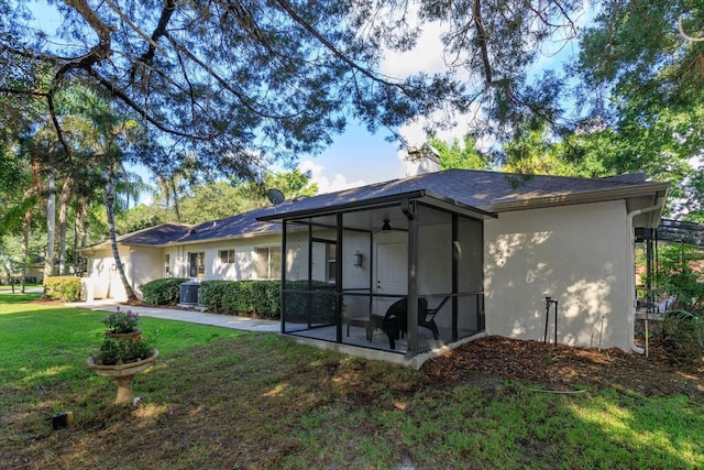 view of front facade featuring a sunroom, a front lawn, a patio area, and central air condition unit