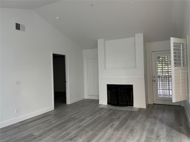 unfurnished living room with wood-type flooring, lofted ceiling, and a fireplace