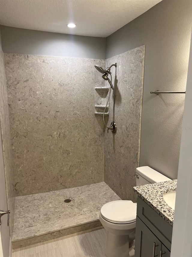 bathroom featuring vanity, a shower, toilet, and hardwood / wood-style flooring