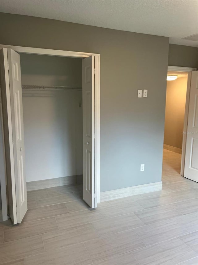 unfurnished bedroom featuring a closet and a textured ceiling