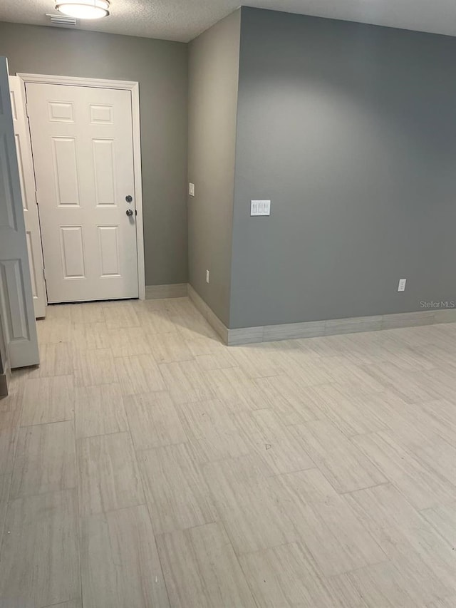 unfurnished room with a textured ceiling