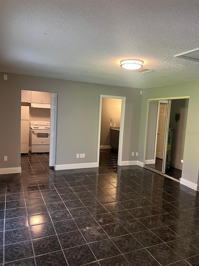 unfurnished room with a textured ceiling