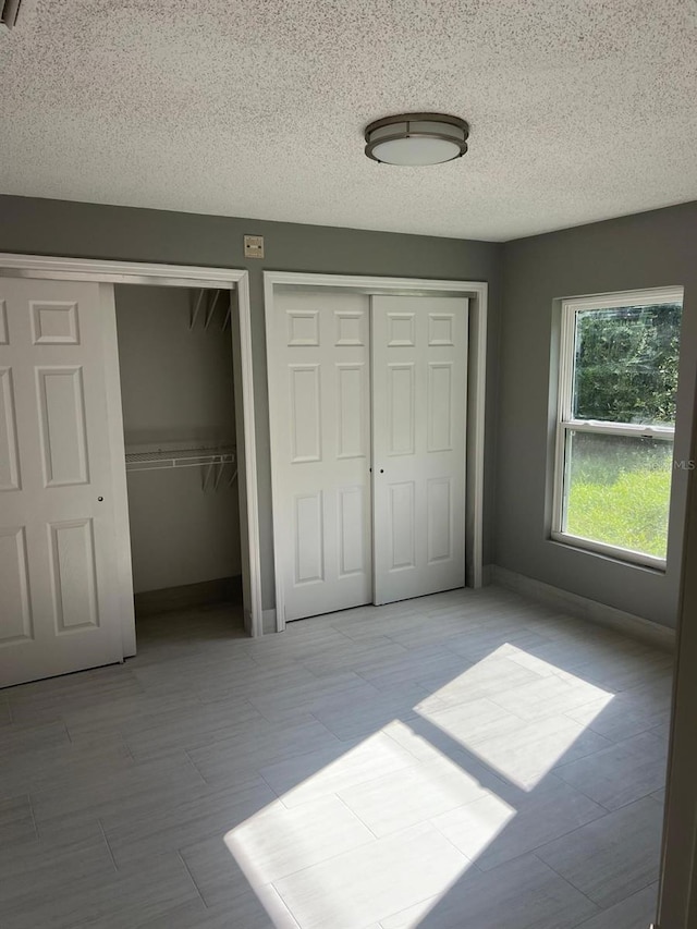 unfurnished bedroom with multiple closets and a textured ceiling