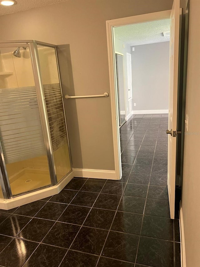 bathroom with an enclosed shower, tile patterned floors, and a textured ceiling