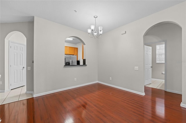 empty room featuring light hardwood / wood-style flooring and a chandelier