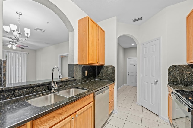 kitchen featuring light tile patterned floors, sink, tasteful backsplash, stainless steel appliances, and dark stone countertops