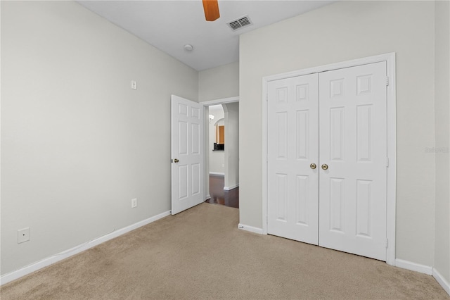 unfurnished bedroom with light carpet, a closet, and ceiling fan