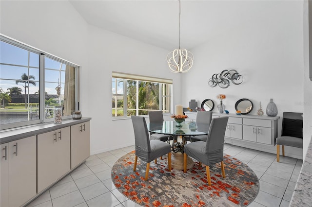 dining space with a water view, vaulted ceiling, and light tile patterned floors