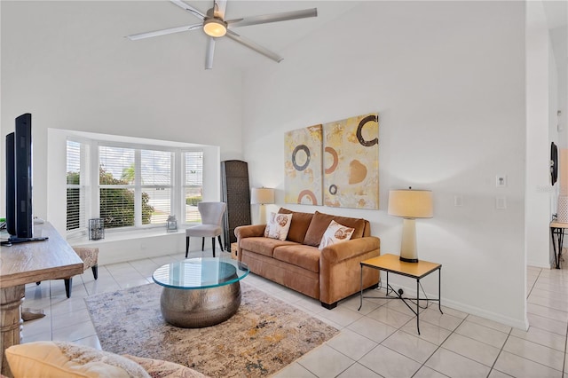 living room with a towering ceiling, light tile patterned flooring, and ceiling fan