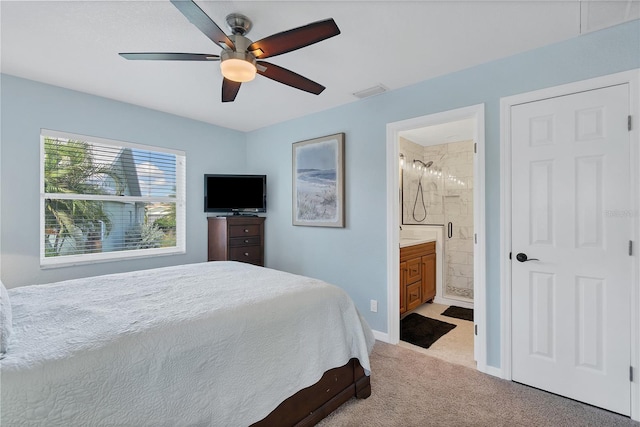 bedroom featuring ceiling fan, ensuite bath, and light carpet