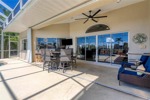 view of patio with glass enclosure and ceiling fan