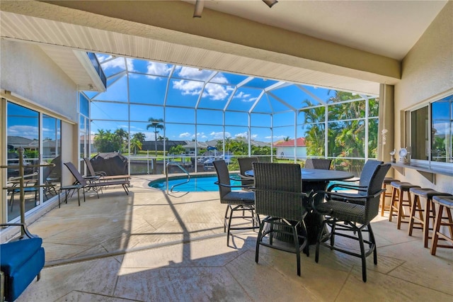 view of patio featuring exterior bar and glass enclosure