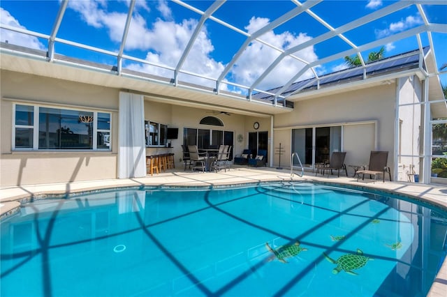 view of swimming pool featuring a patio and a lanai