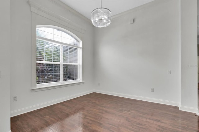 unfurnished room featuring dark hardwood / wood-style floors, crown molding, and a chandelier