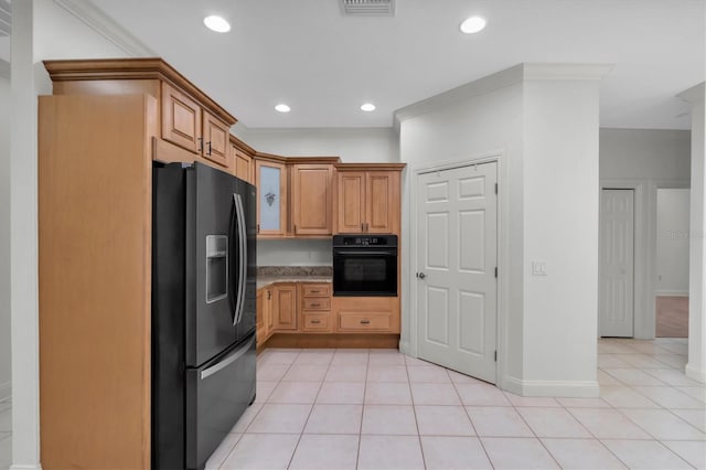 kitchen featuring black oven, stainless steel fridge, light tile patterned floors, and crown molding