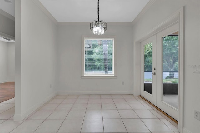 unfurnished dining area featuring a healthy amount of sunlight, crown molding, and french doors