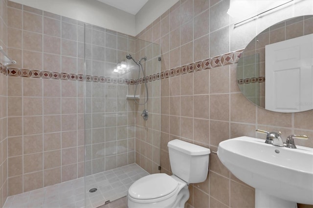 bathroom featuring decorative backsplash, a tile shower, sink, tile walls, and toilet