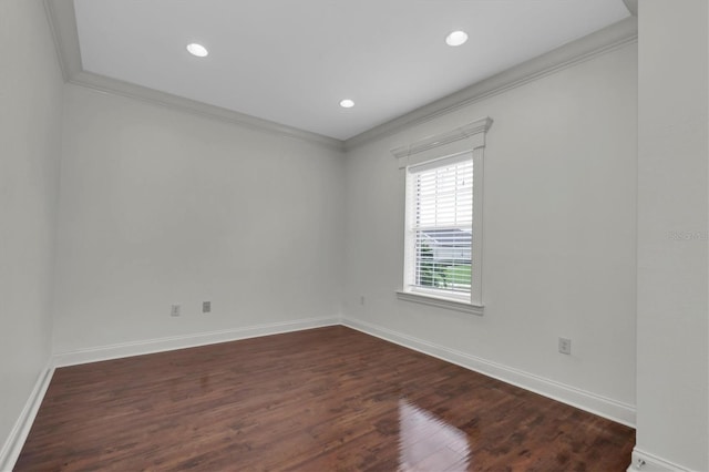 unfurnished room with ornamental molding and dark wood-type flooring