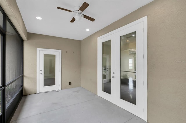 unfurnished sunroom featuring ceiling fan and french doors