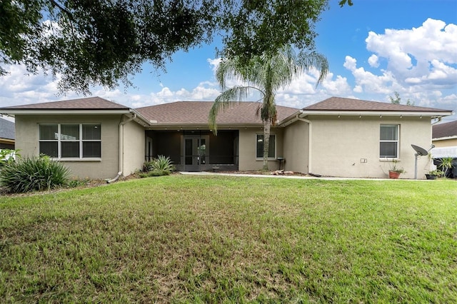 rear view of property featuring a lawn and a sunroom