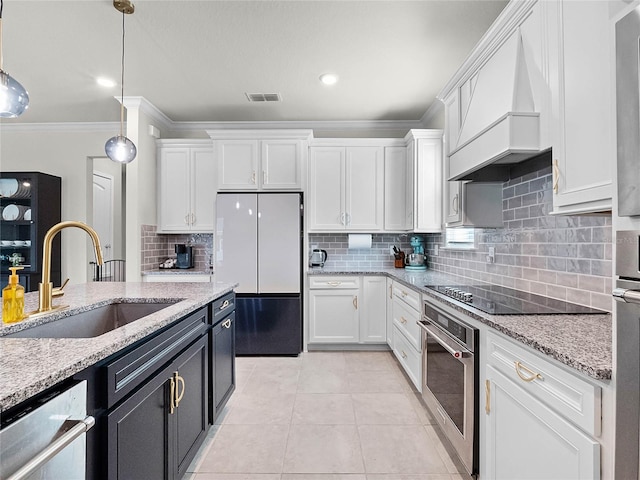 kitchen with white cabinetry, stainless steel appliances, sink, and hanging light fixtures