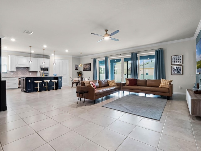 living room with crown molding, light tile patterned floors, and ceiling fan