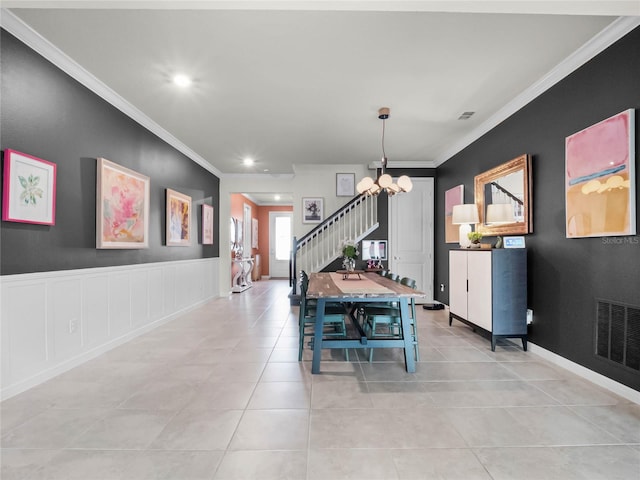 dining room with an inviting chandelier, ornamental molding, and light tile patterned flooring