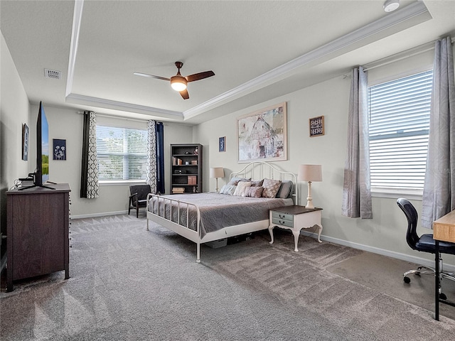 bedroom featuring carpet flooring, multiple windows, a tray ceiling, and ceiling fan