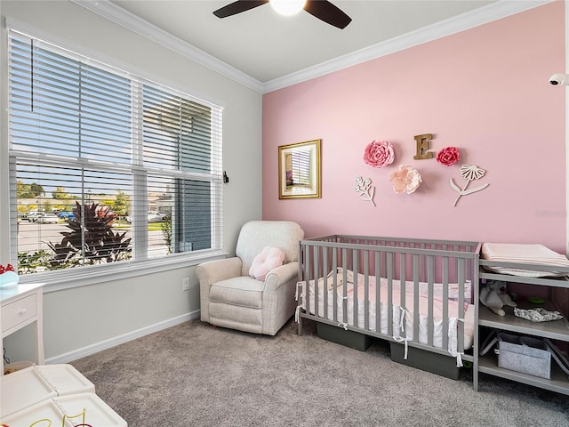 carpeted bedroom with ceiling fan, crown molding, and a nursery area