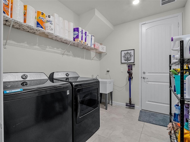 laundry area with sink, light tile patterned flooring, and separate washer and dryer