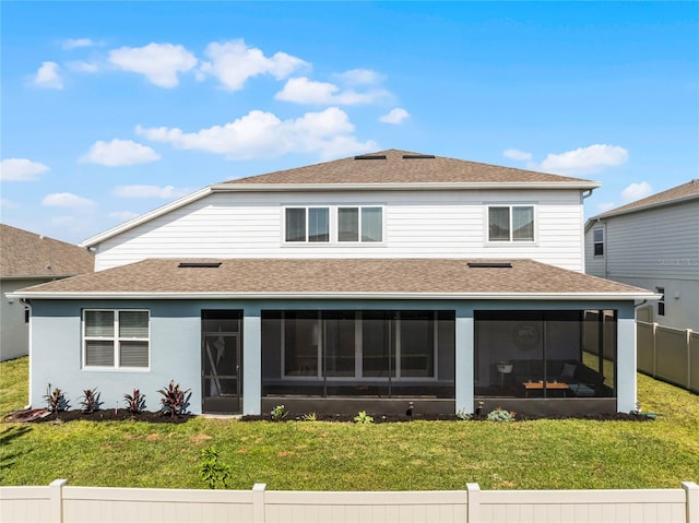 rear view of house with a lawn and a sunroom