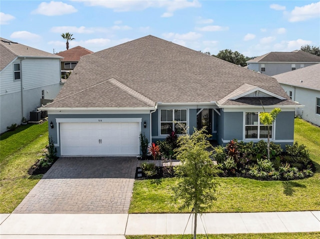 view of front facade featuring a front yard, cooling unit, and a garage